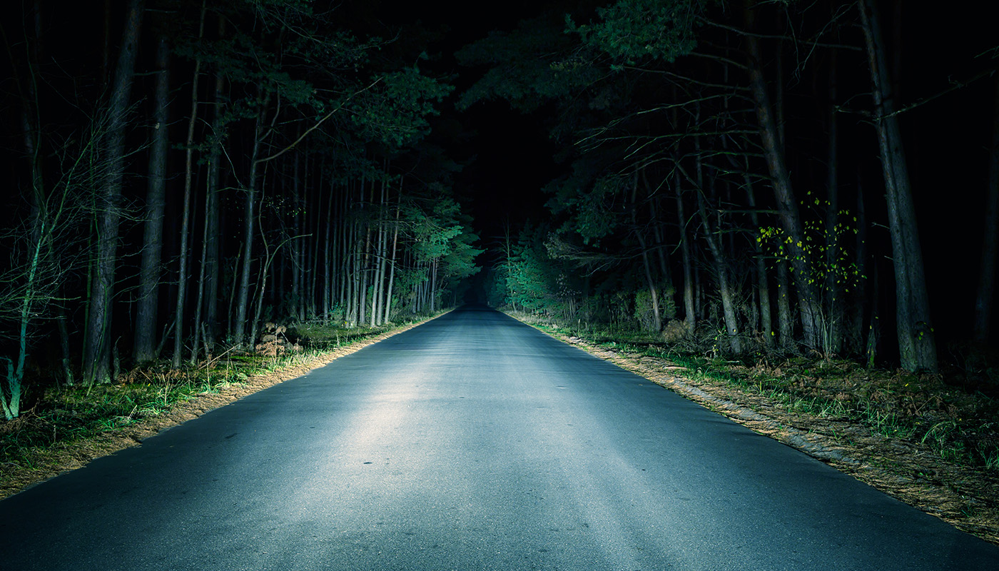 Dark road illuminated by headlights